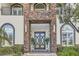 Close up of the stone entryway with double doors and manicured landscaping at 5367 Secluded Brook Ct, Las Vegas, NV 89149