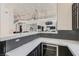 Contemporary kitchen with white marble counters, black backsplash and stainless wine fridge at 5367 Secluded Brook Ct, Las Vegas, NV 89149