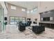 Open-concept living room featuring soaring ceilings, marble floors, a wet bar, and a view of the backyard at 5367 Secluded Brook Ct, Las Vegas, NV 89149