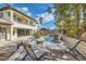 Beautiful backyard pool with a stone waterfall, lush landscaping, and outdoor seating at 5367 Secluded Brook Ct, Las Vegas, NV 89149
