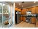 Well-lit kitchen featuring stainless steel appliances, wooden cabinetry and breakfast table overlooking the backyard at 6623 Brick House Ave, Las Vegas, NV 89122