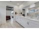 Bright bathroom with dual sink vanity, white cabinets, and a view to the connected bedroom at 6830 Compass St, North Las Vegas, NV 89084
