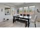 Bright dining area with large windows and a dark wood dining table at 6830 Compass St, North Las Vegas, NV 89084