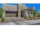 Modern home exterior with a large garage, arched entry, and desert landscaping at 6830 Compass St, North Las Vegas, NV 89084