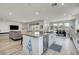 Bright kitchen with an island and stainless steel appliances, flowing into the living and dining areas at 6830 Compass St, North Las Vegas, NV 89084