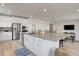Open-concept kitchen with stainless steel appliances, island, and seamless flow into the living area at 6830 Compass St, North Las Vegas, NV 89084