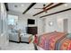 Bedroom showcasing a ceiling fan, dark wood beams, and a seating area at 6830 Compass St, North Las Vegas, NV 89084