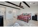Bedroom with exposed ceiling beams, a ceiling fan, an ensuite bathroom and tiled floors at 6830 Compass St, North Las Vegas, NV 89084