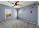 Bedroom with carpet, natural light from two windows, and a stylish ceiling fan at 7189 Ashcroft St, North Las Vegas, NV 89084