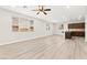Bright living room with light wood flooring and modern ceiling fan, open to the kitchen at 7189 Ashcroft St, North Las Vegas, NV 89084
