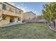 A view of the spacious backyard of this home, featuring fresh green grass and desert landscaping at 7337 Savannah Falls St, Las Vegas, NV 89131