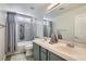Modern bathroom featuring dual sink vanity, tiled shower-tub, and decorative mirror at 7337 Savannah Falls St, Las Vegas, NV 89131
