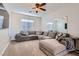 Comfortable living room featuring plush sectional sofa, carpet flooring, and ceiling fan at 7337 Savannah Falls St, Las Vegas, NV 89131