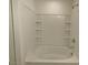 Bright bathroom features a soaking tub with tiled walls and built-in shelving at 7412 Bewitching Ct, Las Vegas, NV 89149