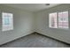 Bright bedroom features two windows and neutral carpet at 7412 Bewitching Ct, Las Vegas, NV 89149