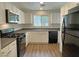Well-lit kitchen featuring white cabinets, laminate flooring and stainless steel appliances at 7412 Bewitching Ct, Las Vegas, NV 89149