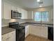 Well-lit kitchen featuring white cabinets, laminate flooring and stainless steel appliances at 7412 Bewitching Ct, Las Vegas, NV 89149