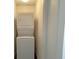 A stacked washer and dryer set in a small closet at 7412 Bewitching Ct, Las Vegas, NV 89149