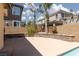 Large backyard area with concrete, low stone wall, palm trees, and perimeter fence, great for entertaining and outdoor activities at 7736 Villa Andrade Ave, Las Vegas, NV 89131