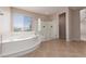 Bright bathroom showcasing a large soaking tub and glass enclosed shower at 7736 Villa Andrade Ave, Las Vegas, NV 89131