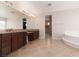 Bathroom featuring tile floors, double sinks, granite counters and soaking tub at 7736 Villa Andrade Ave, Las Vegas, NV 89131