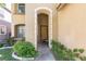 Inviting entryway framed by stone archway and green foliage with flowers at 7736 Villa Andrade Ave, Las Vegas, NV 89131