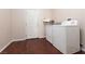 Bright laundry room with white washer and dryer, and a door leading outside at 7736 Villa Andrade Ave, Las Vegas, NV 89131