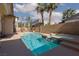 Sparkling pool with a tanning ledge, spa, and lush landscaping with palms at 7736 Villa Andrade Ave, Las Vegas, NV 89131