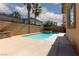 Sparkling pool with a tanning ledge, spa, and lush landscaping with palms at 7736 Villa Andrade Ave, Las Vegas, NV 89131