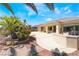 Manicured backyard with stone landscaping, a built-in grill, and palm trees at 8236 Imperial Lakes St, Las Vegas, NV 89131