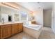 Bathroom with double sinks, a soaking tub, and wood cabinets at 8236 Imperial Lakes St, Las Vegas, NV 89131