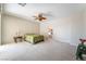 Bedroom view with a ceiling fan, neutral carpet, and access to a bathroom at 8236 Imperial Lakes St, Las Vegas, NV 89131