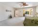 Large bedroom with a ceiling fan, neutral carpet, and glass doors to a patio at 8236 Imperial Lakes St, Las Vegas, NV 89131