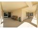 Spacious covered patio with windows and sliding glass door with four chairs at 8236 Imperial Lakes St, Las Vegas, NV 89131