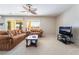 The living room has plush carpet, comfortable seating, a ceiling fan, and large windows at 8236 Imperial Lakes St, Las Vegas, NV 89131