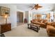Living room view with carpet, ceiling fan, sofa, and entry to the kitchen at 8236 Imperial Lakes St, Las Vegas, NV 89131