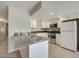 Well-lit kitchen with bar seating featuring stainless steel appliances, white cabinets, and neutral countertops at 8804 River Pines Ct # 202, Las Vegas, NV 89117