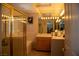 A tiled bathroom features a glass-enclosed shower, soaking tub, vanity with mirror and lighting fixtures at 9905 Fox Springs Dr, Las Vegas, NV 89117