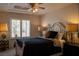 Comfortable bedroom featuring a ceiling fan, plantation shutters, and neutral decor at 9905 Fox Springs Dr, Las Vegas, NV 89117