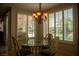 Bright dining area with large windows, a glass table, and chairs, providing a lovely view of the backyard pool at 9905 Fox Springs Dr, Las Vegas, NV 89117