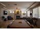 Spacious living room with fireplace, pool table, tile flooring, and plantation shutters at 9905 Fox Springs Dr, Las Vegas, NV 89117