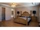 A bedroom with a decorative wooden bed frame, and a wooden dresser with a lamp and accessories on each side at 9905 Fox Springs Dr, Las Vegas, NV 89117