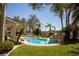 A backyard pool with rock features, slide, tropical landscaping, lush grass, and an outdoor seating area at 9905 Fox Springs Dr, Las Vegas, NV 89117