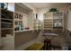 A walk-in closet featuring custom shelving and storage, a stool, keyboard, Gathering photos, and an orchid at 9905 Fox Springs Dr, Las Vegas, NV 89117