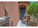 Covered entryway with a stylish blue front door and verdant landscaping at 10030 Trotter Peak St, Las Vegas, NV 89178