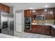 Eat-in kitchen with stainless appliances, tile backsplash, and warm wood cabinetry at 10030 Trotter Peak St, Las Vegas, NV 89178