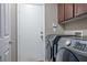 Functional laundry room equipped with modern Samsung washer and dryer units, storage cabinets, and easy access to the exterior at 10030 Trotter Peak St, Las Vegas, NV 89178