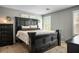 Elegant main bedroom showcasing a decorative dark wood bed frame, plush carpet, and ample natural light from shuttered windows at 10030 Trotter Peak St, Las Vegas, NV 89178