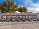 Stone signage for Mountain's Edge community, enhanced with greenery, offering an inviting entrance and neighborhood charm at 10030 Trotter Peak St, Las Vegas, NV 89178
