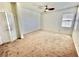 Bright bedroom features neutral carpet, a ceiling fan, and a window for ample natural light at 10680 Sapphire Vista Ave, Las Vegas, NV 89144